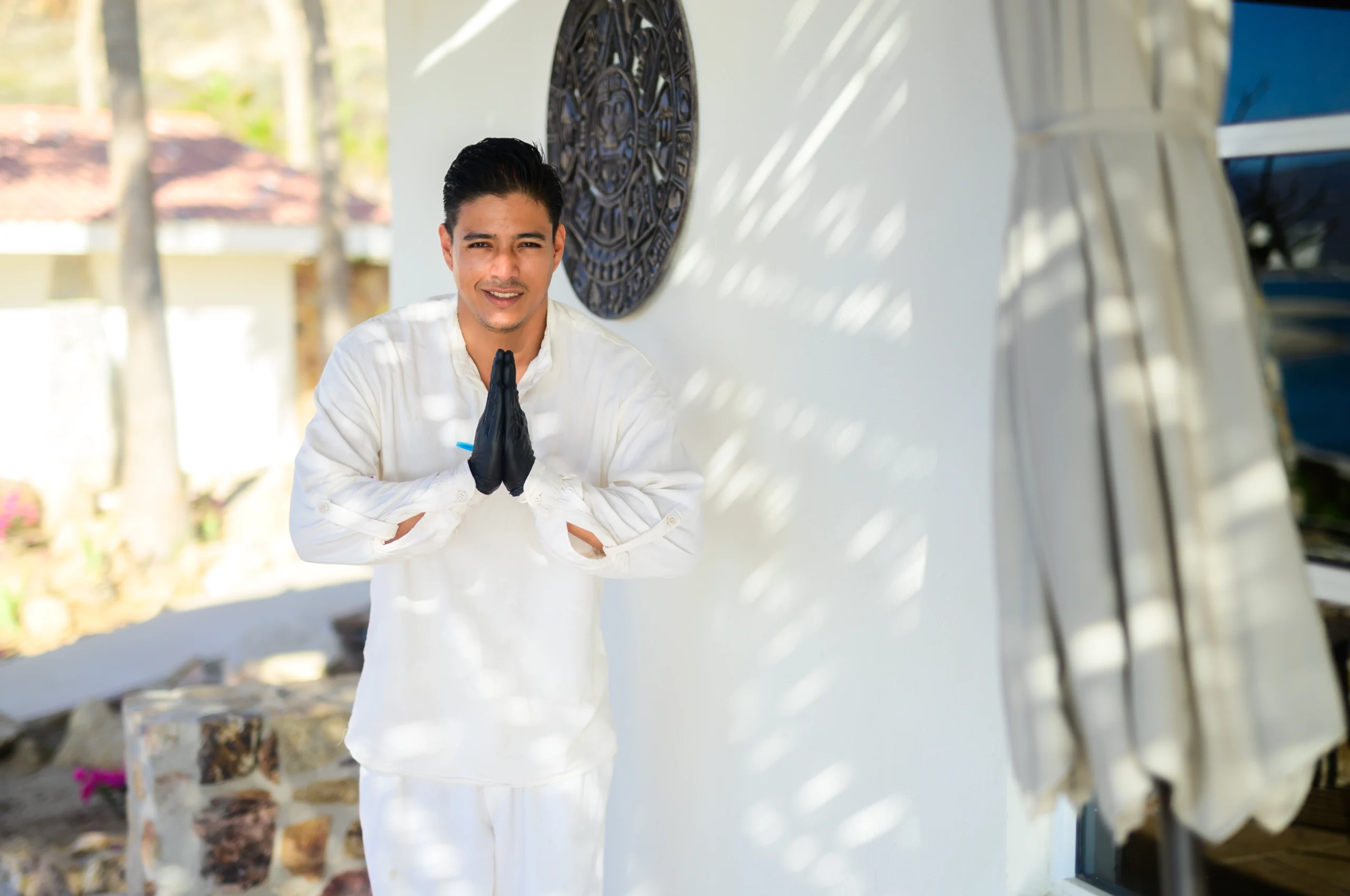 a man in white clothes standing in front of a wall